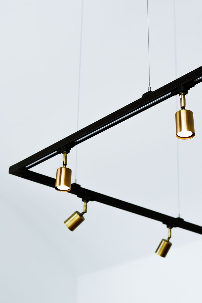 Elegant minimalist gold hanging lights on geometric frame indoors.